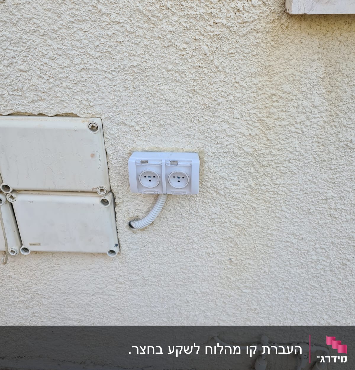 שקע חשמל כפול מותקן על קיר חיצוני